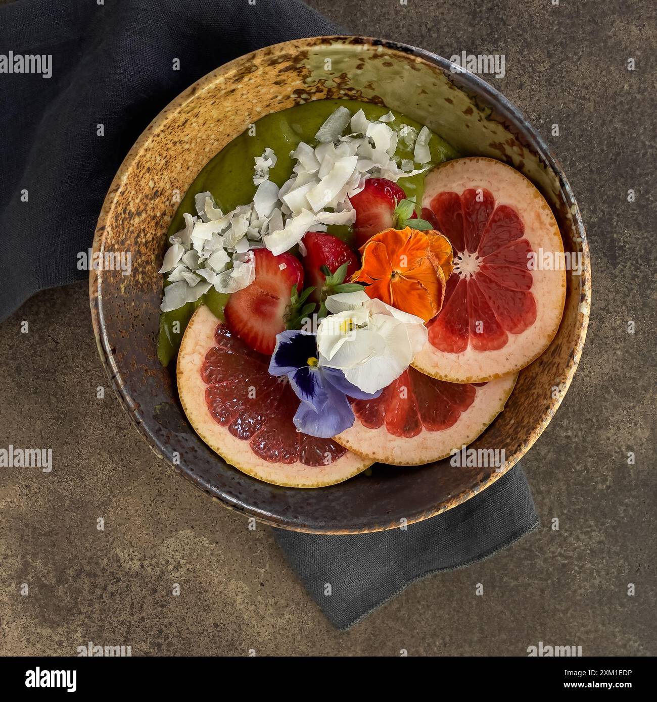 Matcha Smoothie Schüssel mit Orangen-, Erdbeeren- und Kokosflocken, wunderschön dekoriert. Stockfoto