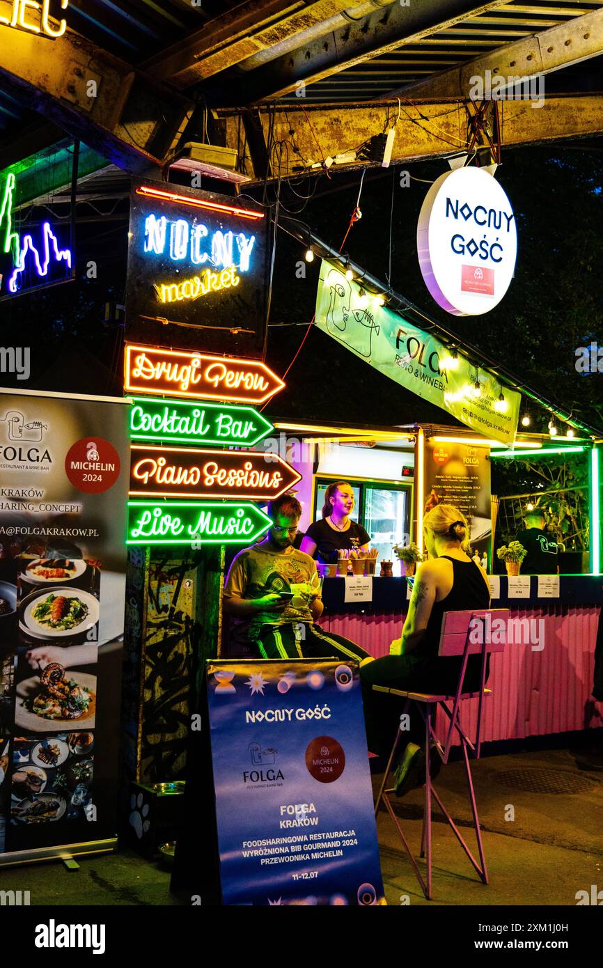 Neonschilder und Folga x Nocny Gosc Stand, Nocny Market (Nachtmarkt) Lebensmittelmarkt auf ehemaligen Bahnsteigen des Hauptbahnhofs in Warschau, Polen Stockfoto