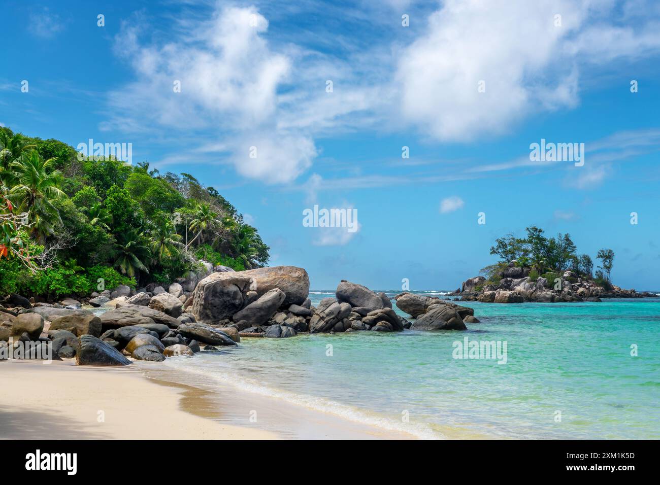 Felsen, Felsbrocken und Palmen am malerischen tropischen Sandstrand von Mahé, Seychellen Stockfoto