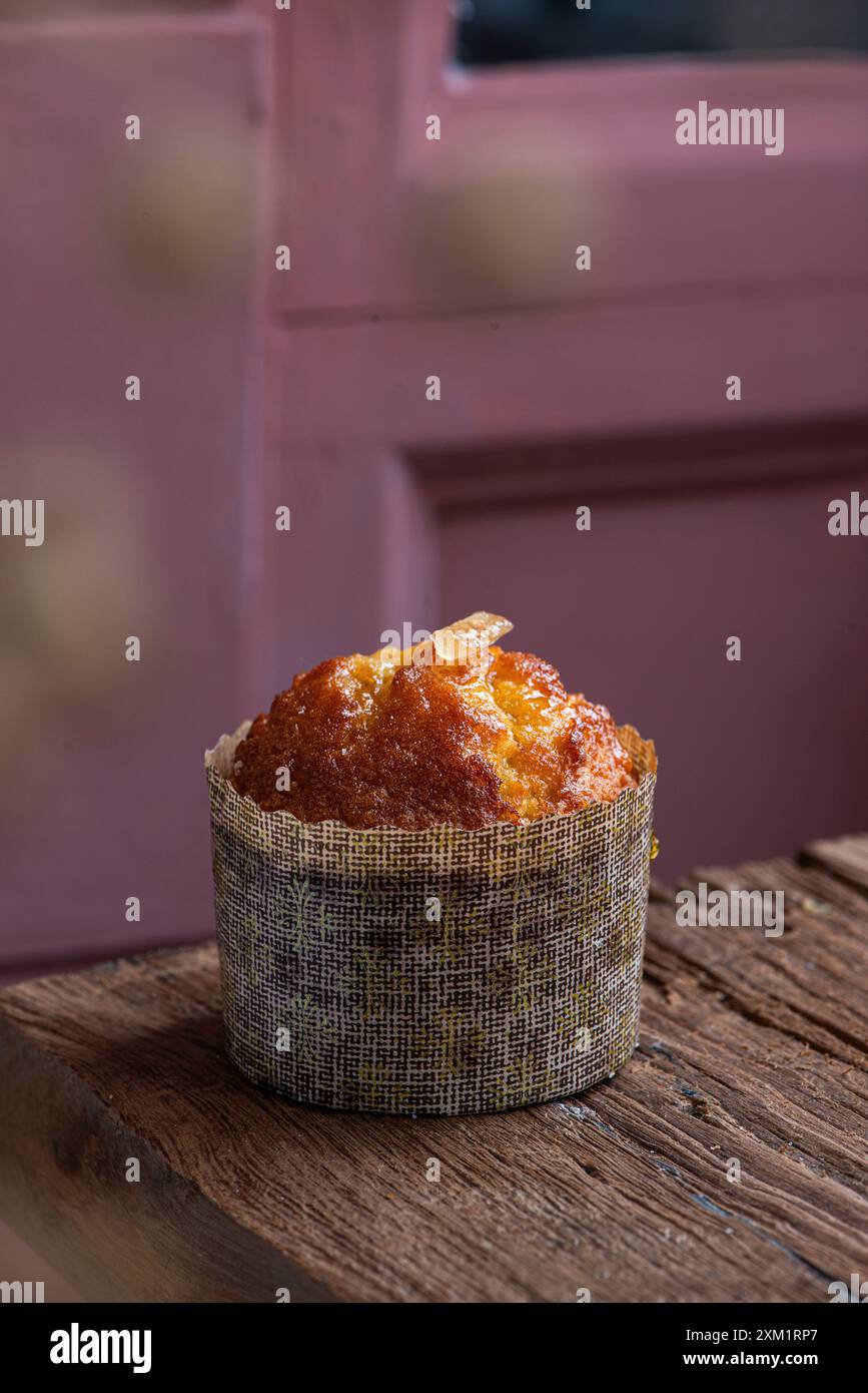 Orangefarbener Muffin auf einem Holztisch. Frisch gebacken. Stockfoto