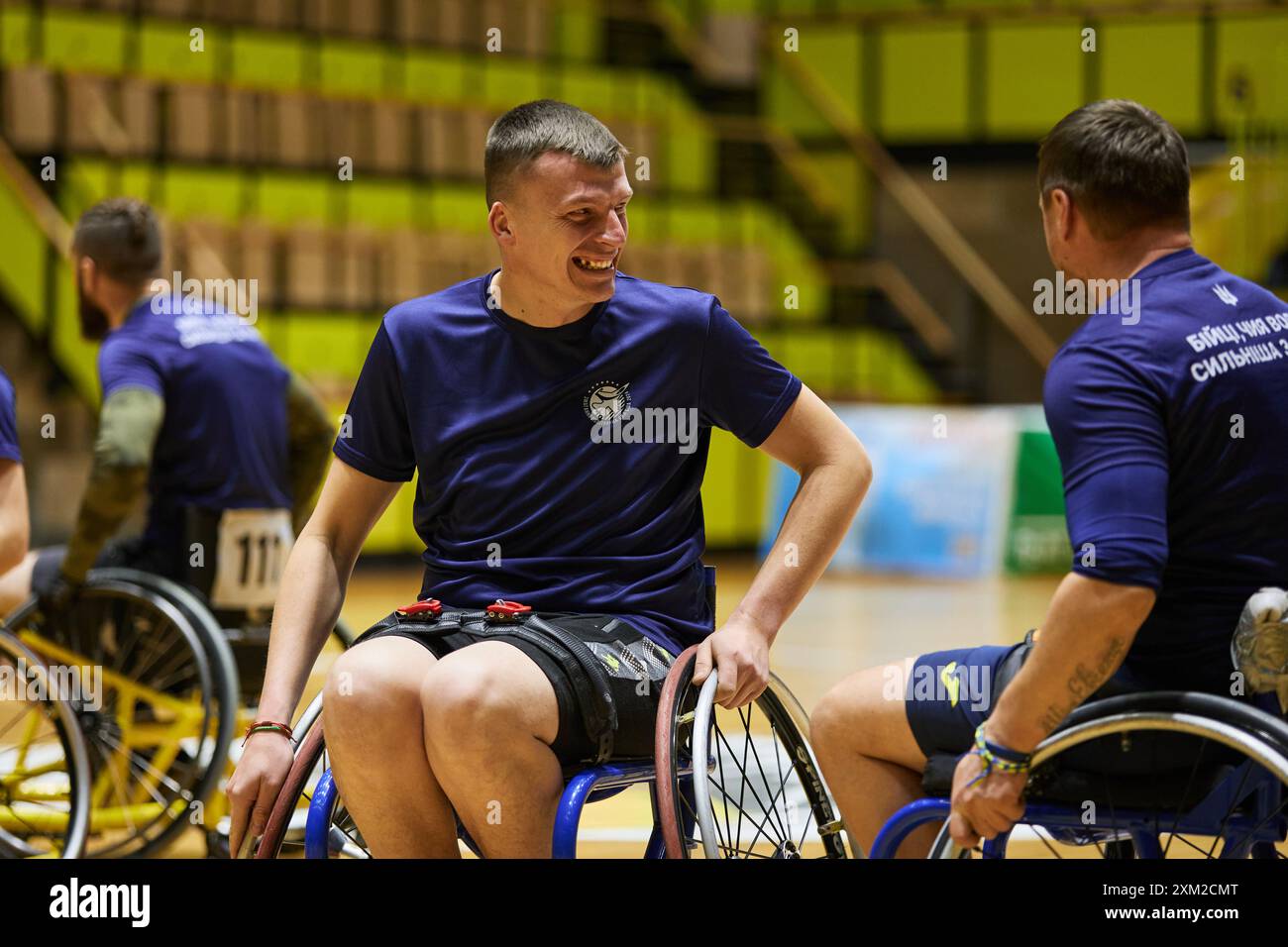 Fröhlicher gelähmter Basketballspieler im Rollstuhl. Ein ukrainischer Veteran spielt adaptiven Sport. Kiew - 12. Dezember 2023 Stockfoto