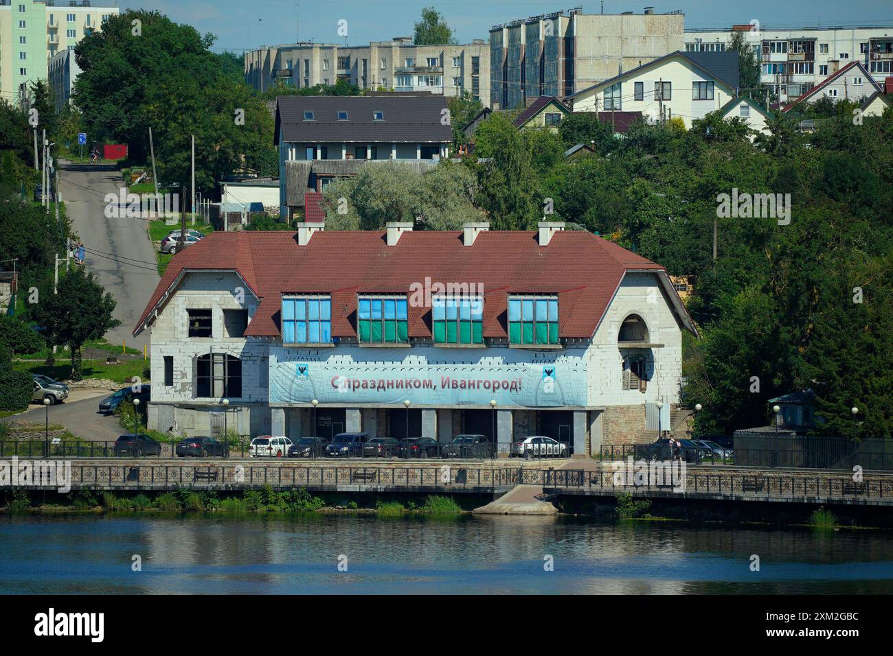 Warschau, Polen. Juli 2024. Ein Gebäude mit dem Banner „Happy Holidays, Ivangorod“ ist am 24. Juli 2024 in Ivangorod, Russland, auf der anderen Seite des Flusses Narva in Narva, Estland, zu sehen. Die estnischen Behörden haben die Brücke zwischen Russland und Estland für den gesamten eingehenden Verkehr geschlossen. Die Brücke in Narva ist heute einer der letzten Orte, an denen Besucher direkt nach Russland einreisen können, da der Flugverkehr in das Land fast nicht mehr existiert. (Foto: Jaap Arriens/SIPA USA) Credit: SIPA USA/Alamy Live News Stockfoto