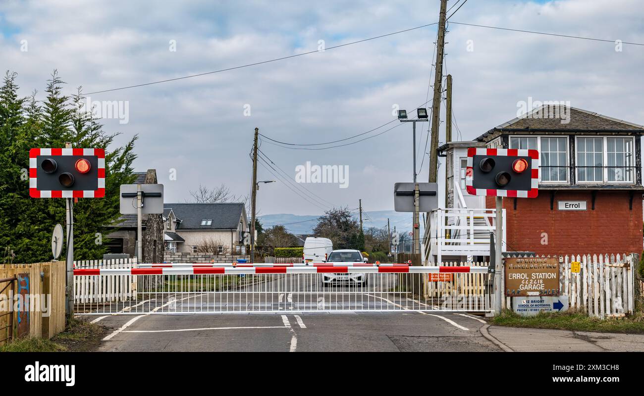 Barrieren und blinkende rote Warnleuchte am Bahnübergang, Errol Station, Perthshire, Schottland, Großbritannien Stockfoto