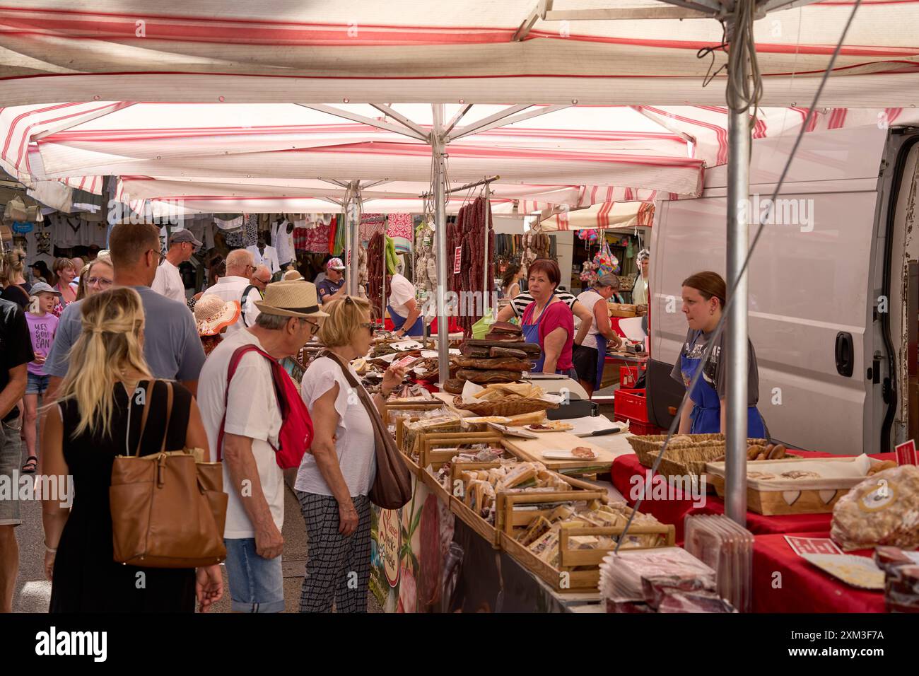 Malcesine, Gardasee, Italien - 20. Juli 2024: Wochenmarkt in Malcesine am Gardasee in Italien. Viele Besucher, darunter Touristen und Einheimische, die regionale Käse- und Wurstprodukte kaufen *** ein Wochenmarkt in Malcesine am Gardasee in Italien. Viele Besucher darunter Touristen und einheimische beim Kauf von regionalen Käse und Wurst Produkte Stockfoto