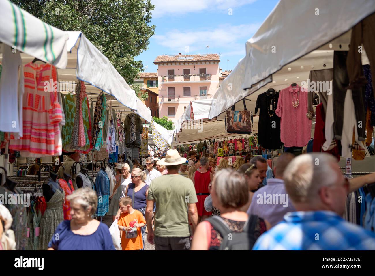 Malcesine, Gardasee, Italien - 20. Juli 2024: Wochenmarkt in Malcesine am Gardasee in Italien. Viele Besucher, darunter Touristen und Einheimische, die ein Schnäppchen suchen *** ein Wochenmarkt in Malcesine am Gardasee in Italien. Viele Besucher darunter Touristen und einheimische auf der Suche nach einem Schnäppchen Stockfoto