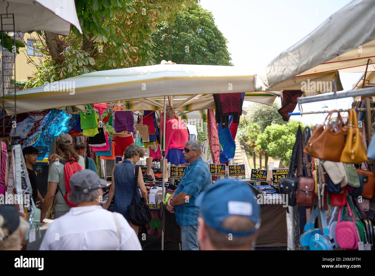 Malcesine, Gardasee, Italien - 20. Juli 2024: Wochenmarkt in Malcesine am Gardasee in Italien. Viele Besucher, darunter Touristen und Einheimische, die ein Schnäppchen suchen *** ein Wochenmarkt in Malcesine am Gardasee in Italien. Viele Besucher darunter Touristen und einheimische auf der Suche nach einem Schnäppchen Stockfoto