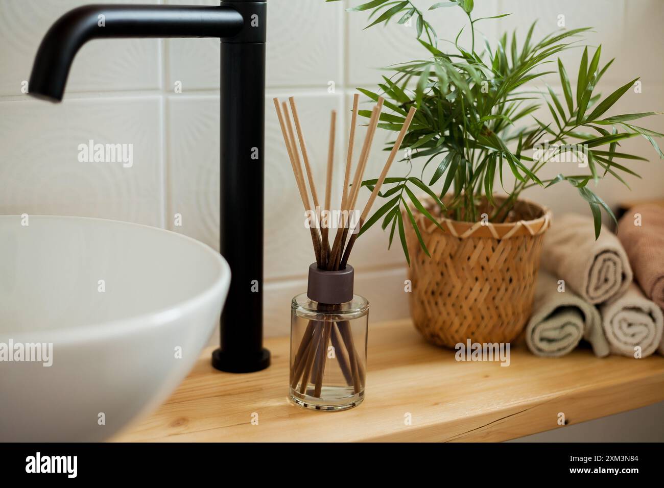 Bad in Schwarz-weiß. Wohnkultur. Waschbecken, Handtücher, Diffusor, Hausblume. Stockfoto