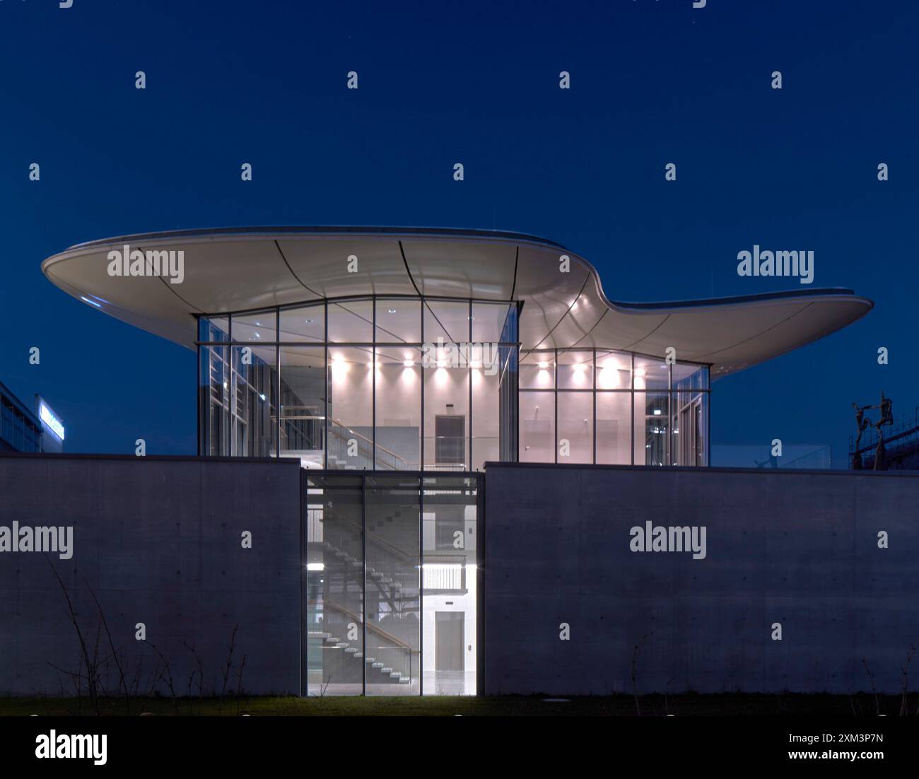 Fassade im obersten Stockwerk mit schwimmendem Dach, beleuchtete Innenräume bei Nacht. Stiftung Froehlich - Sammlung Froehlich, Leinfelden-Echterdingen, Deutschland. Bogen Stockfoto