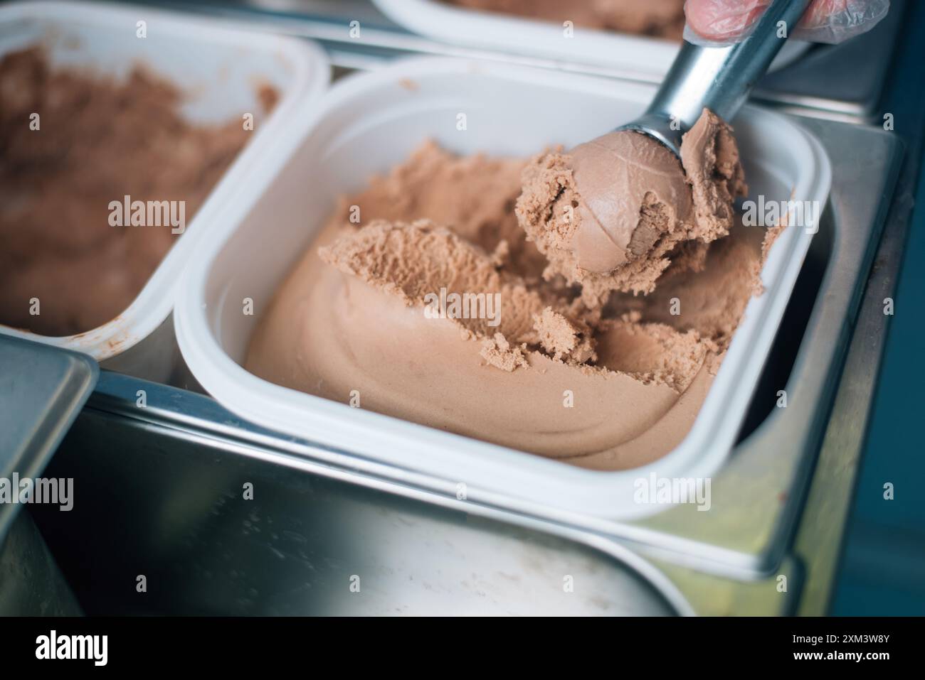 Der Verkäufer legt eine Kugel Eiscreme-Schaufel Stockfoto