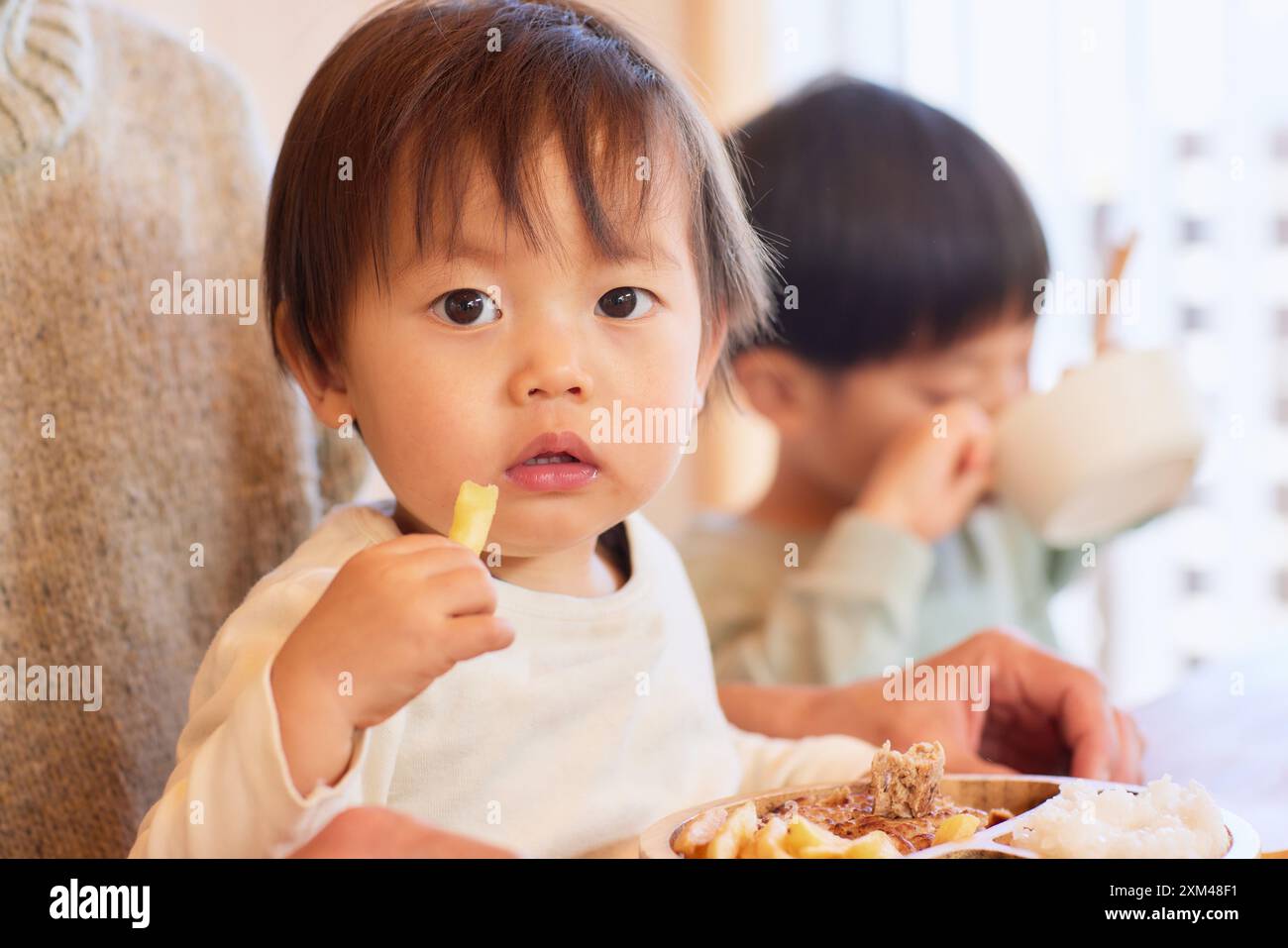 Glückliche japanische Kinder essen im Speisesaal Stockfoto