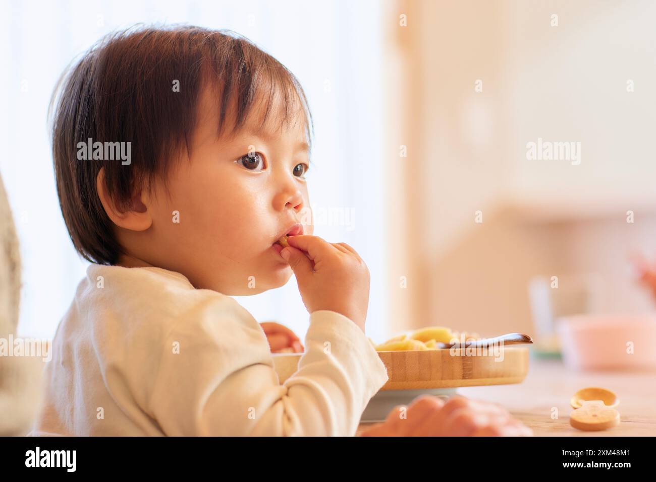 Glückliches japanisches Kind, das im Speisesaal isst Stockfoto