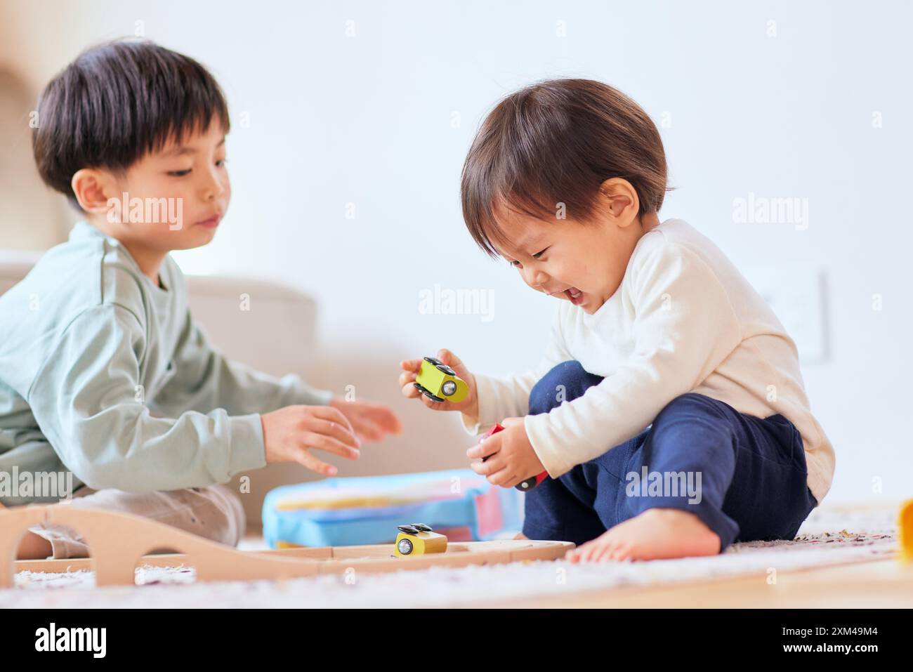 Glückliche japanische Kinder, die auf dem Boden spielen Stockfoto