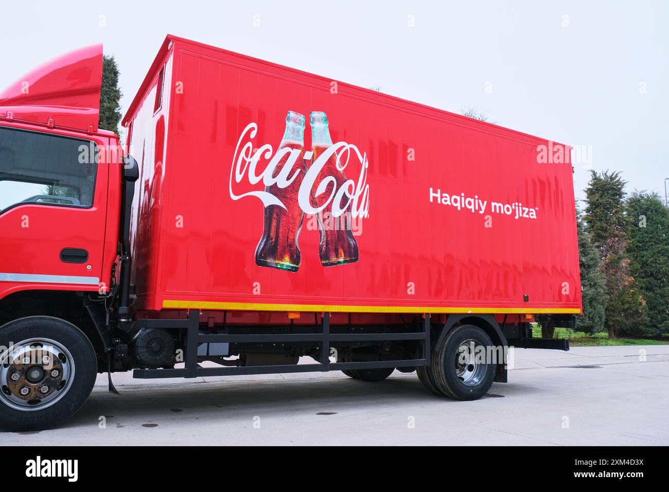 Detail des roten Verteilerwagens mit Usbek, Ein wahres Wunder, auf der Seite. In der CCI Coca Cola Soda Fabrik in Taschkent, Usbekistan. Stockfoto