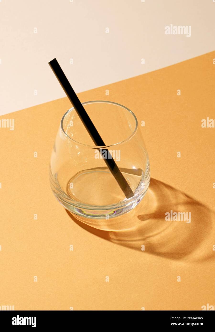 Leeres Cocktailglas mit Strohhalm auf farbenfrohem Hintergrund Stockfoto