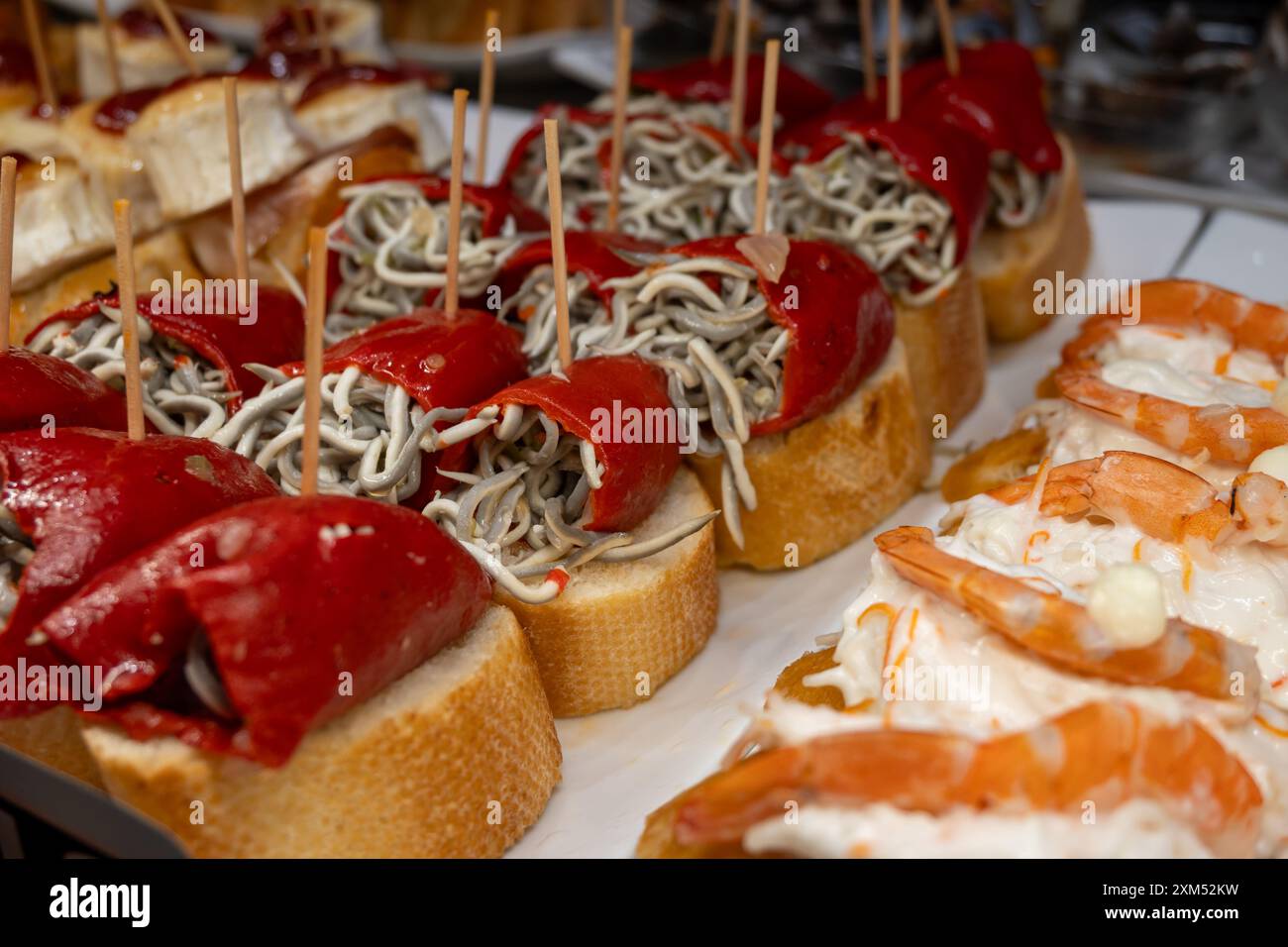 Typische Snacks aus dem Baskenland, verschiedene Pinchos oder Pinxtos im Ofen gebackene Meeresfrüchte, Brot, Sardellen, Garnelensalat, Käse in Bars in San Sebas Stockfoto