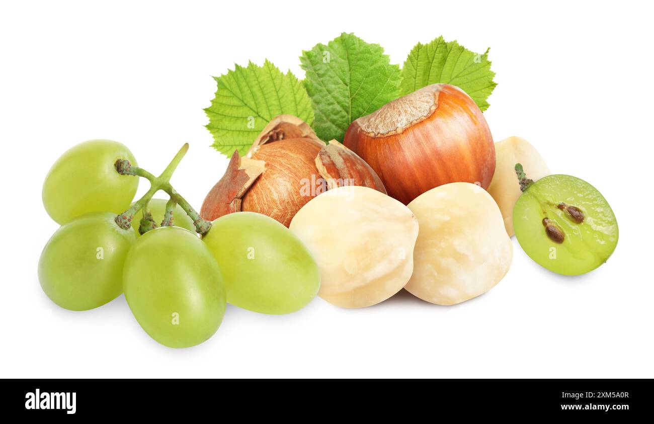 Haselnüsse und grüne Trauben isoliert auf weiß Stockfoto