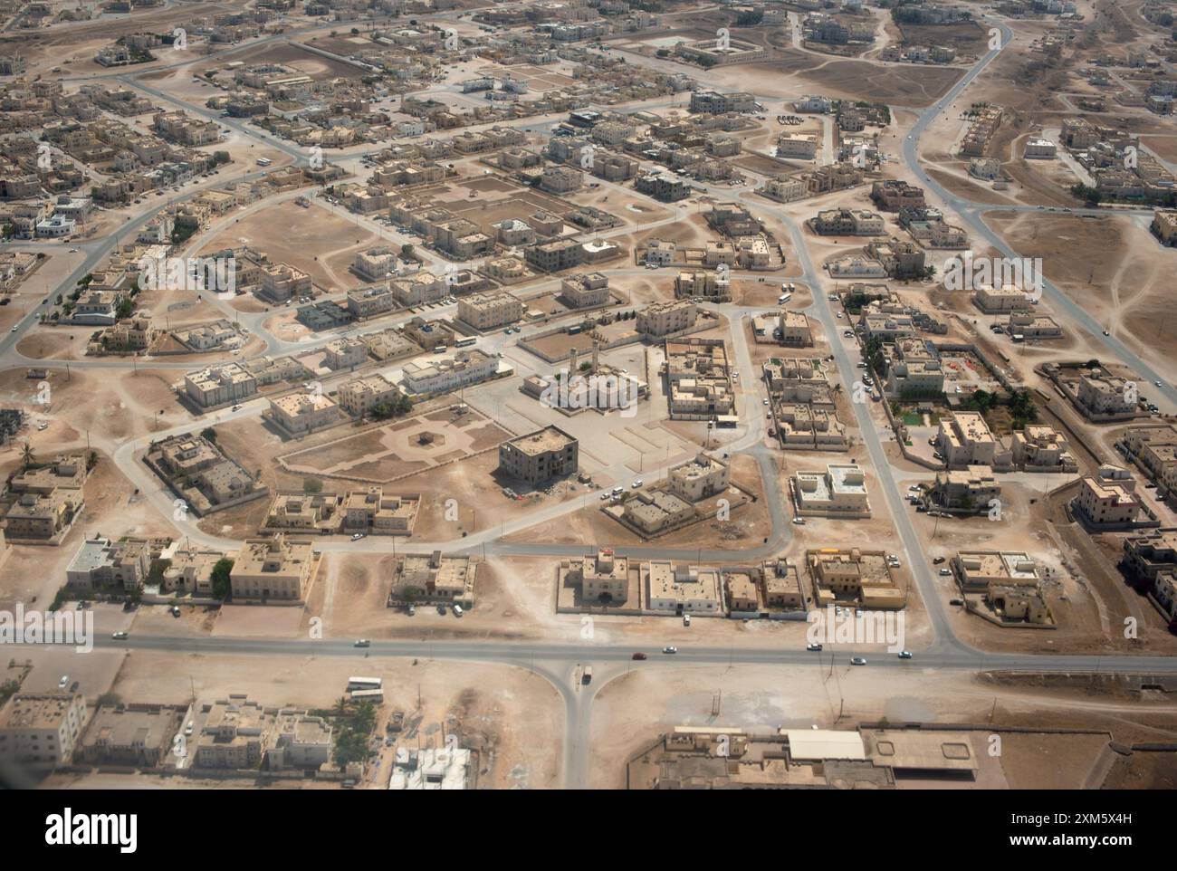 Luftperspektive, die ein weitläufiges Wohnviertel in Maskat, Oman, zeigt, wie das Layout, die Straßen und die Strukturen in einer Wüstenumgebung aussehen Stockfoto