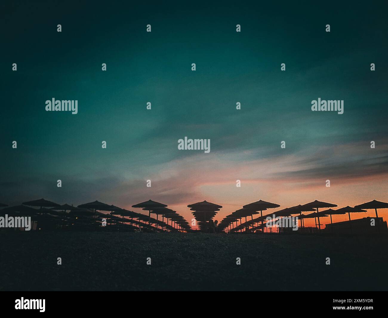 Moody Szene am Mamaia Beach in Constanta, Rumänien mit einem schönen Sonnenuntergang Himmel und Silhouetten von Sonnenschirmen Stockfoto