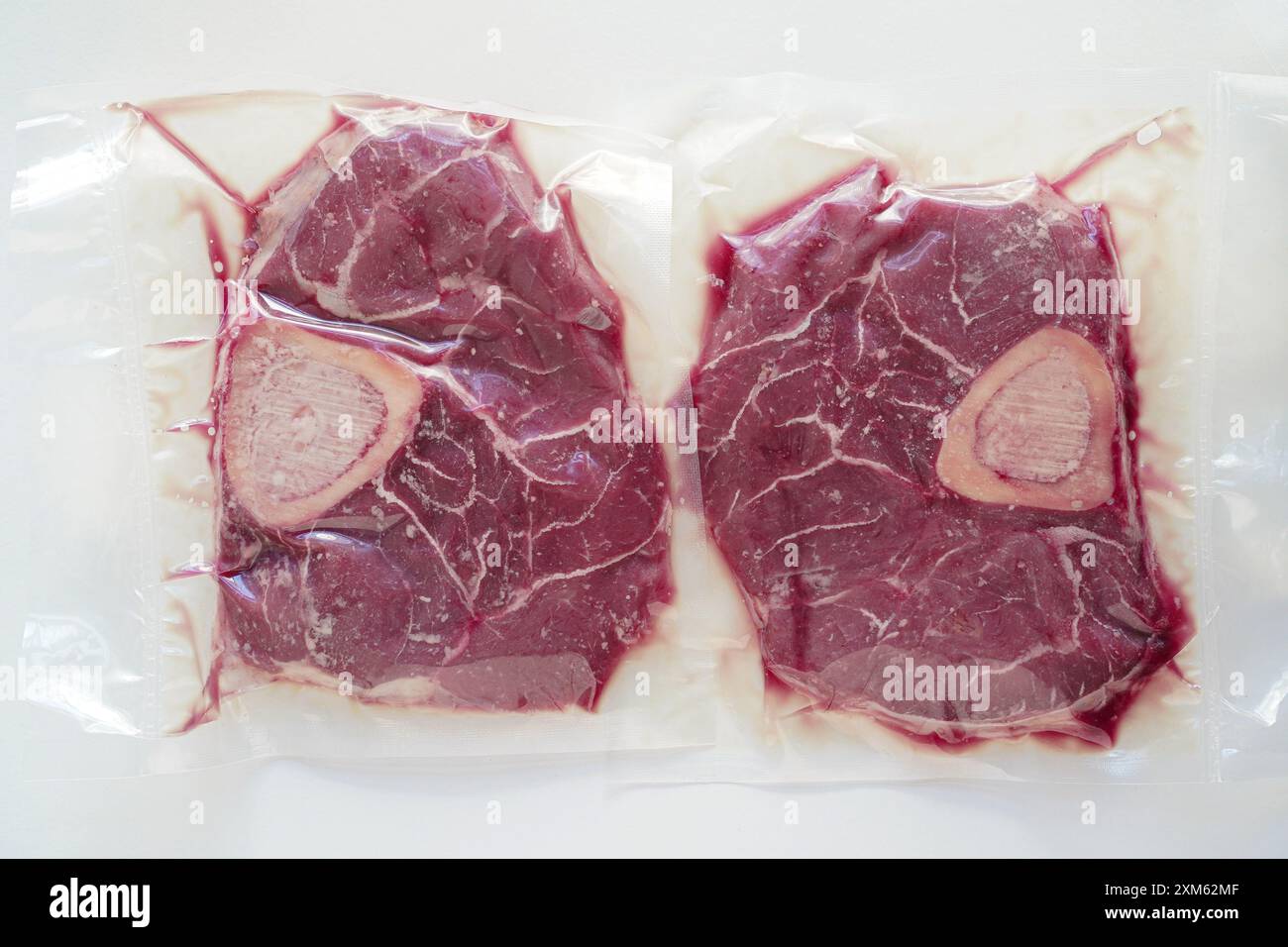 Großaufnahme von Bio-Rindfleisch (osso buco) in einer vakuumversiegelten Verpackung mit weißem Hintergrund Stockfoto