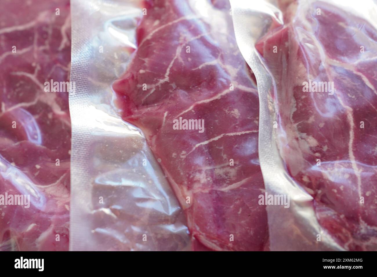 Großaufnahme von Bio-Rindfleisch (osso buco) in einer vakuumversiegelten Verpackung mit weißem Hintergrund Stockfoto