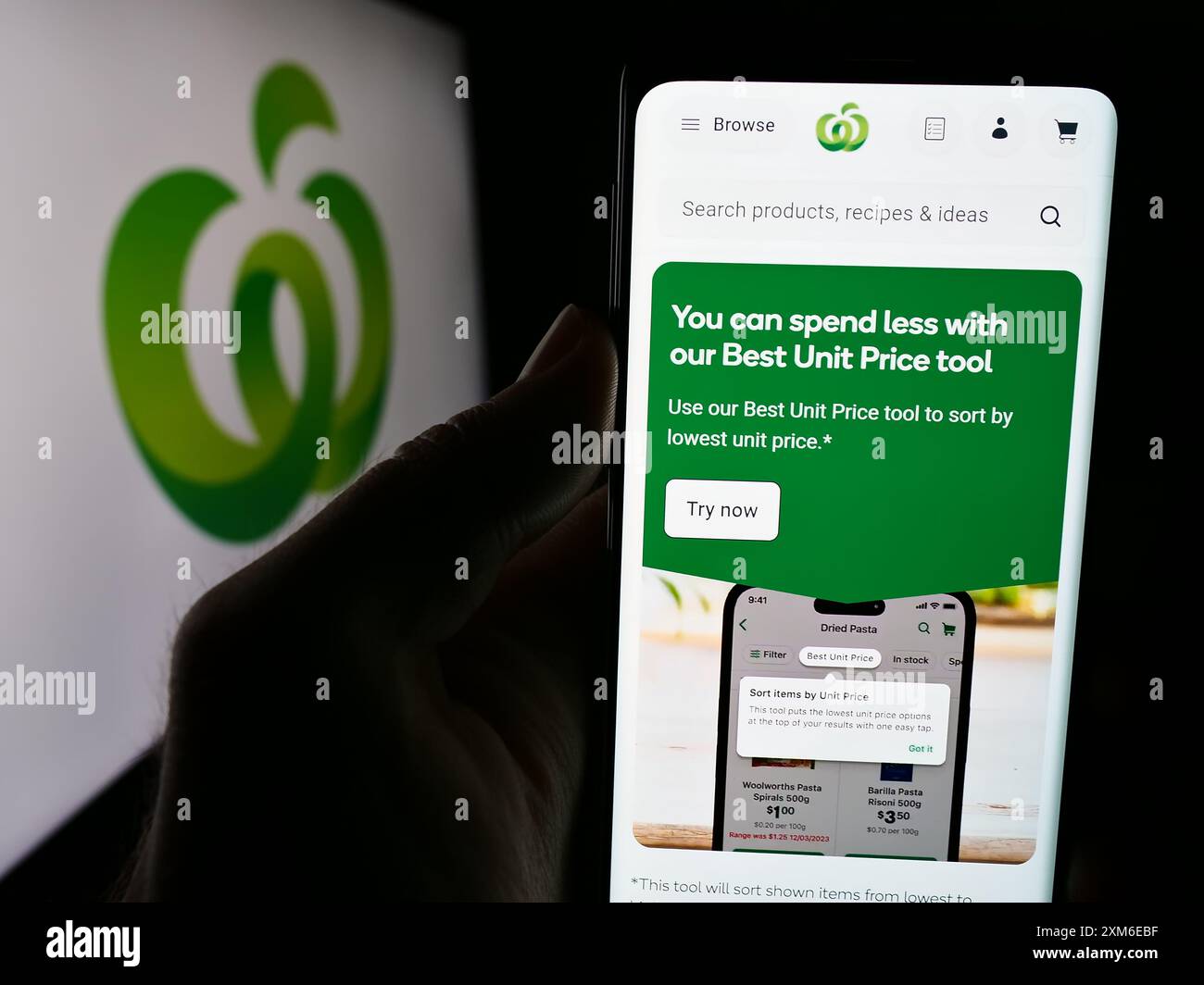 Person, die ein Handy hält, mit Website der australischen Einzelhandelskette Woolworths Supermarkets mit Logo. Konzentrieren Sie sich auf die Mitte des Telefondisplays. Stockfoto