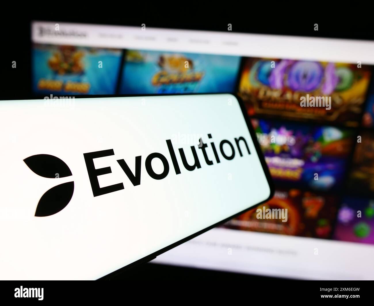 Smartphone mit Logo des schwedischen Glücksspieltechnologieunternehmens Evolution ab vor der Business-Website. Fokussieren Sie sich auf die linke Mitte des Telefondisplays. Stockfoto