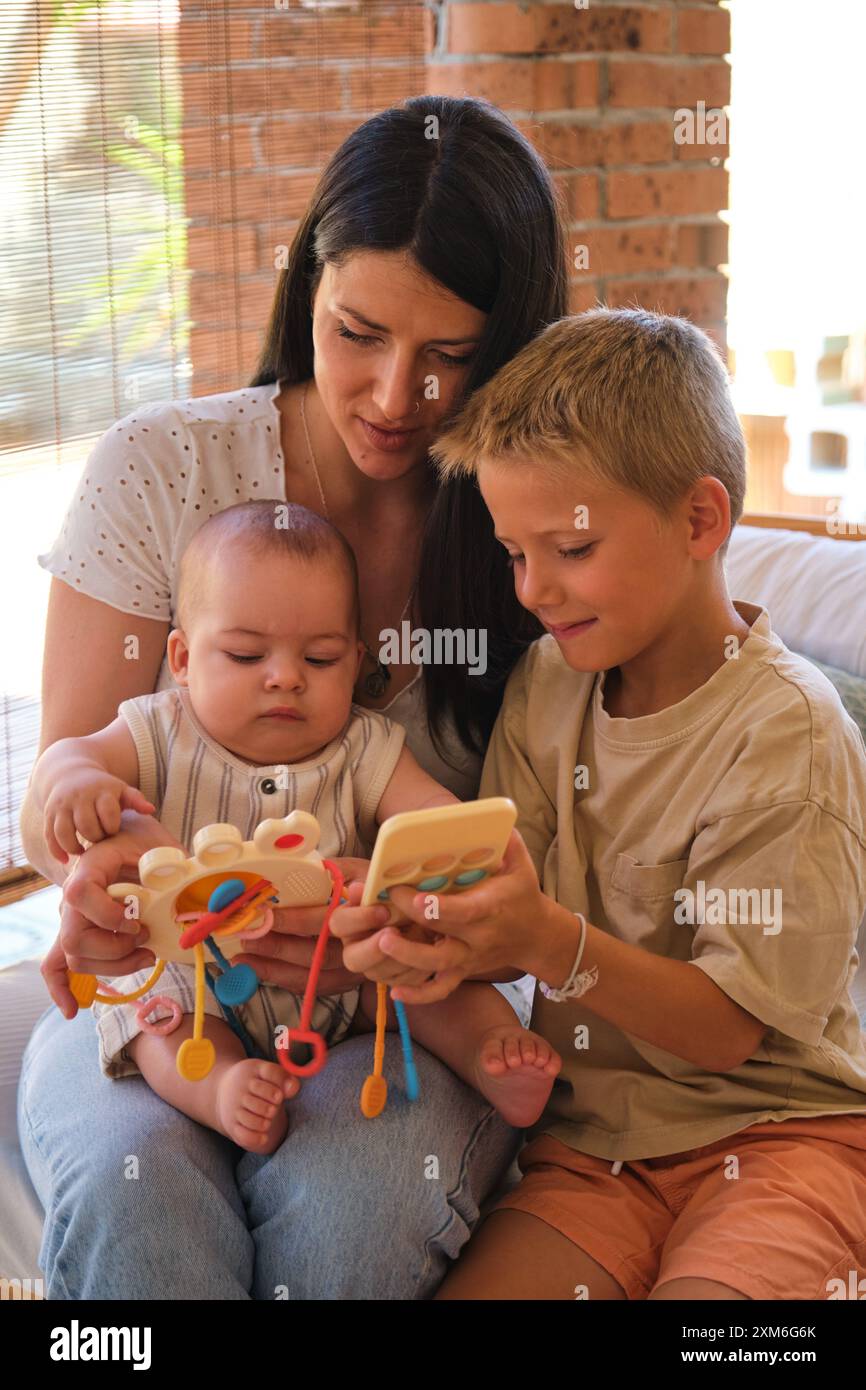 Mutter, die mit Kindern spielt, und pädagogisches Spielzeug zu Hause Stockfoto