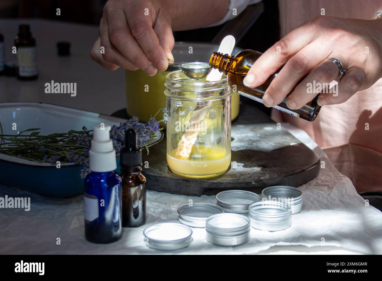 Hände, die Kräutermittel in einem Glas mit ätherischen Ölen vorbereiten Stockfoto
