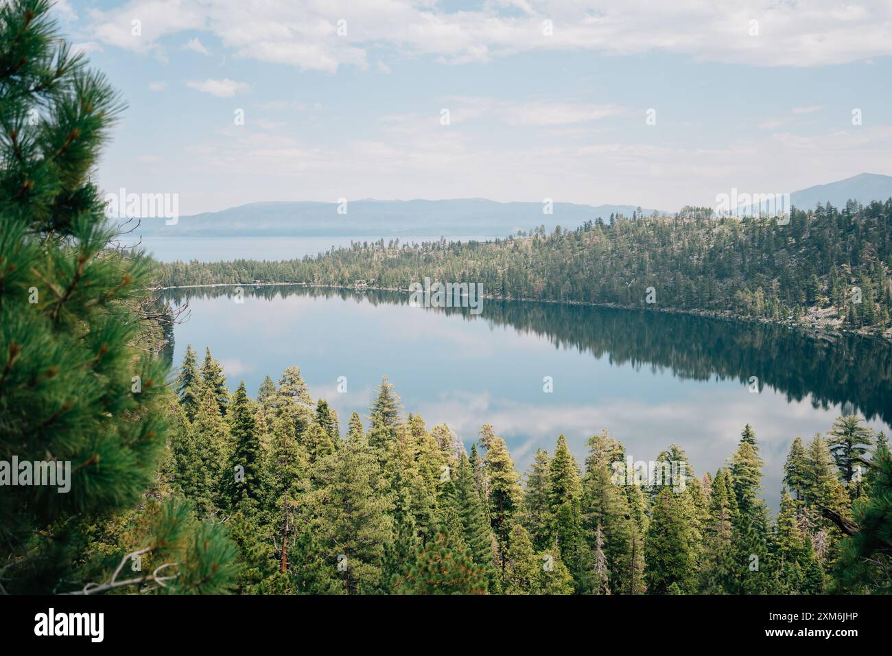 Blick auf die Berge und eine Baumlinie, die von einem See reflektiert wird Stockfoto