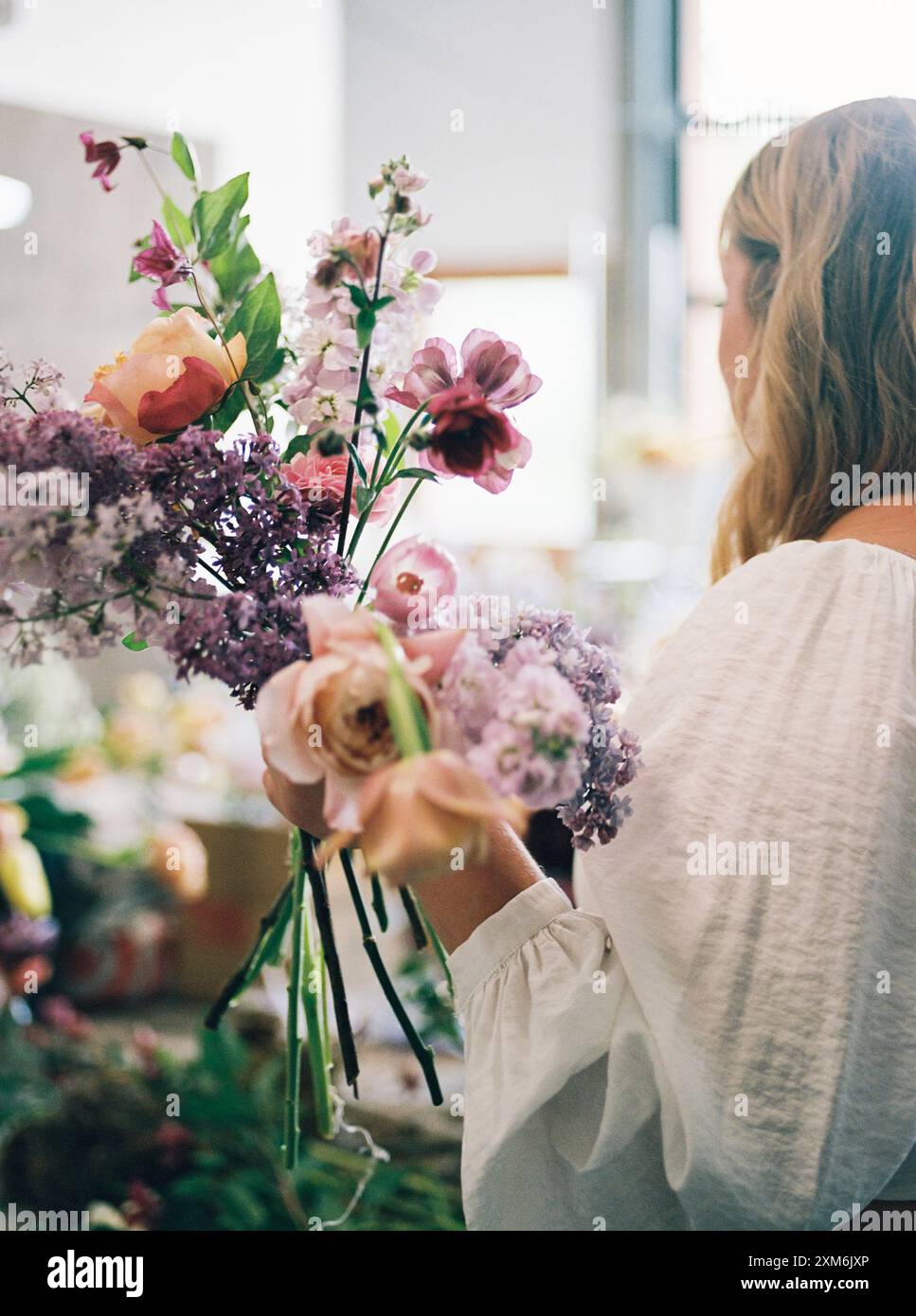 Frau, die einen Blumenstrauß in einem Innenbereich hält Stockfoto