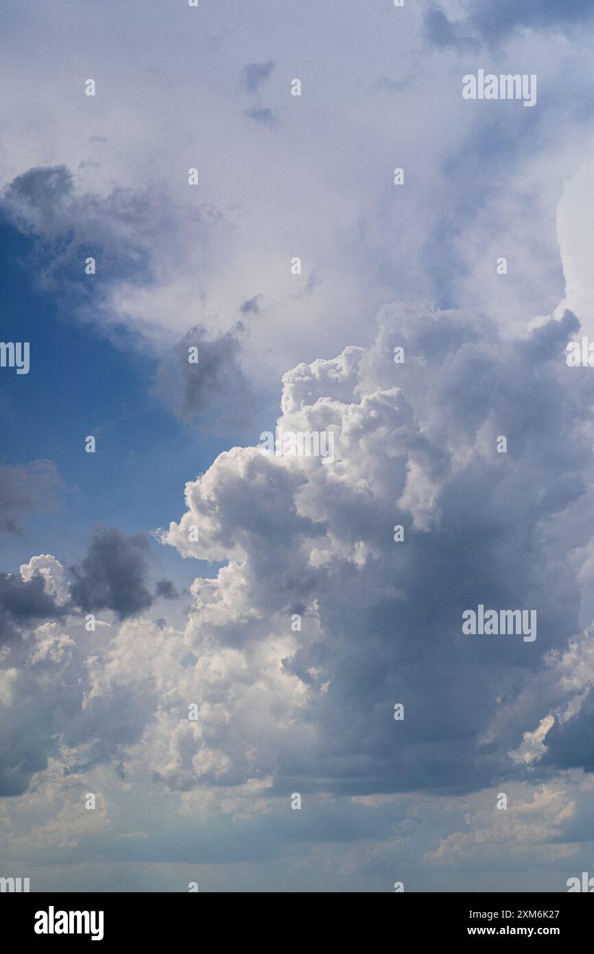 Tiefwinkelansicht des Sonnenlichts, das bei Sonnenuntergang durch Wolken strömt. Stockfoto