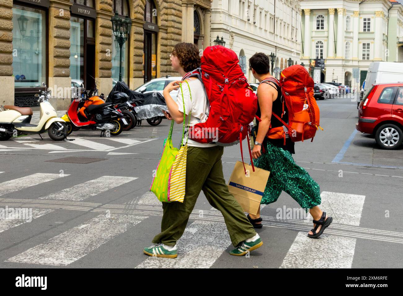 Zwei junge Frauen mit großen Rucksäcken laufen auf der Straße Prag Altstadt Rucksacktouristen Europa Stadt Stockfoto