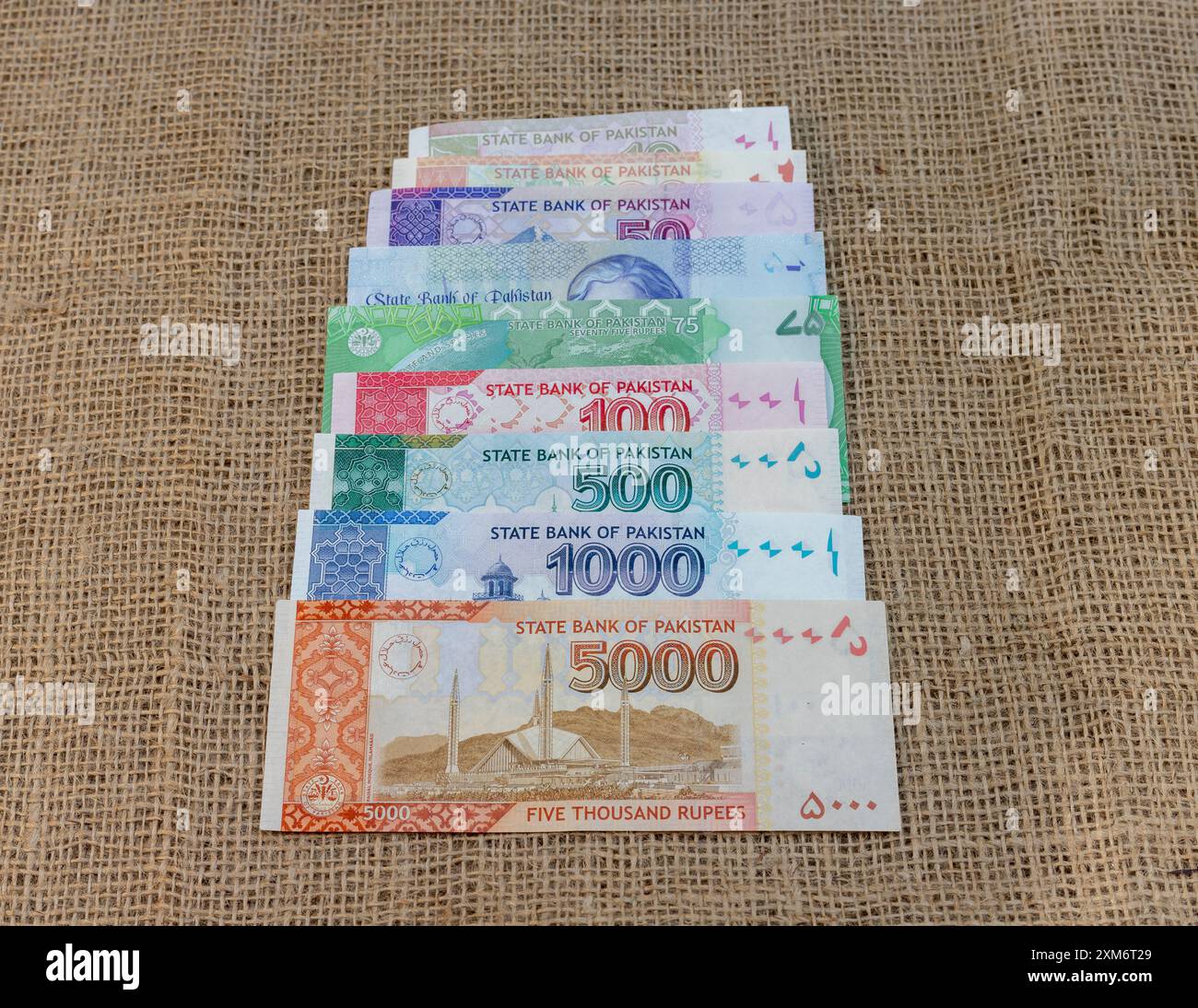 Stapel pakistanischer Banknoten, kompletter Satz auf Sackleinen-Hintergrund Stockfoto