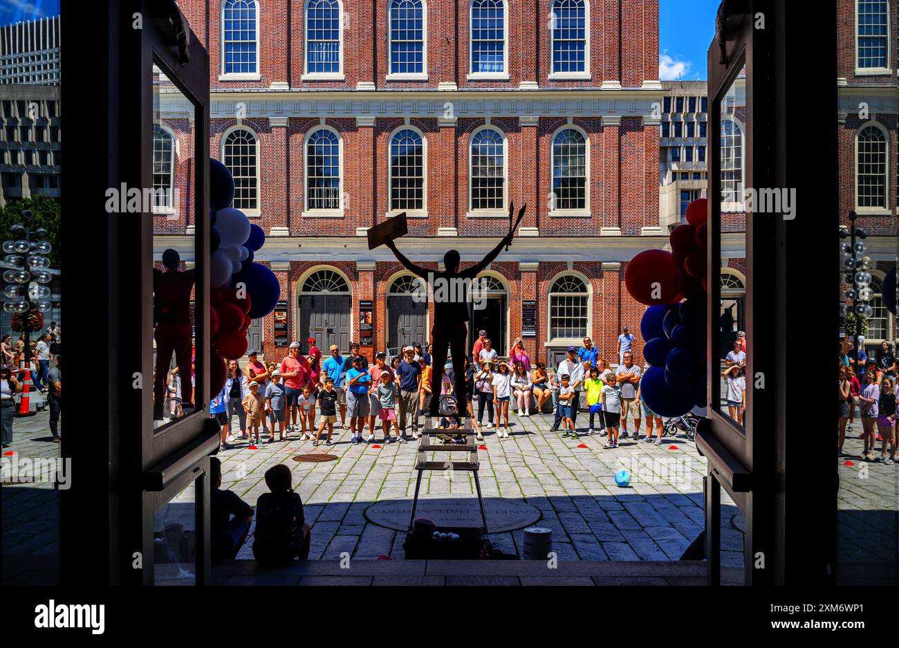 Boston, Massachusetts, USA - 2. Juli 2024: Ein Jongleur tritt vor großer Menschenmenge auf. Blick in Silhouette vom Quincy Market, einem historischen Bu Stockfoto