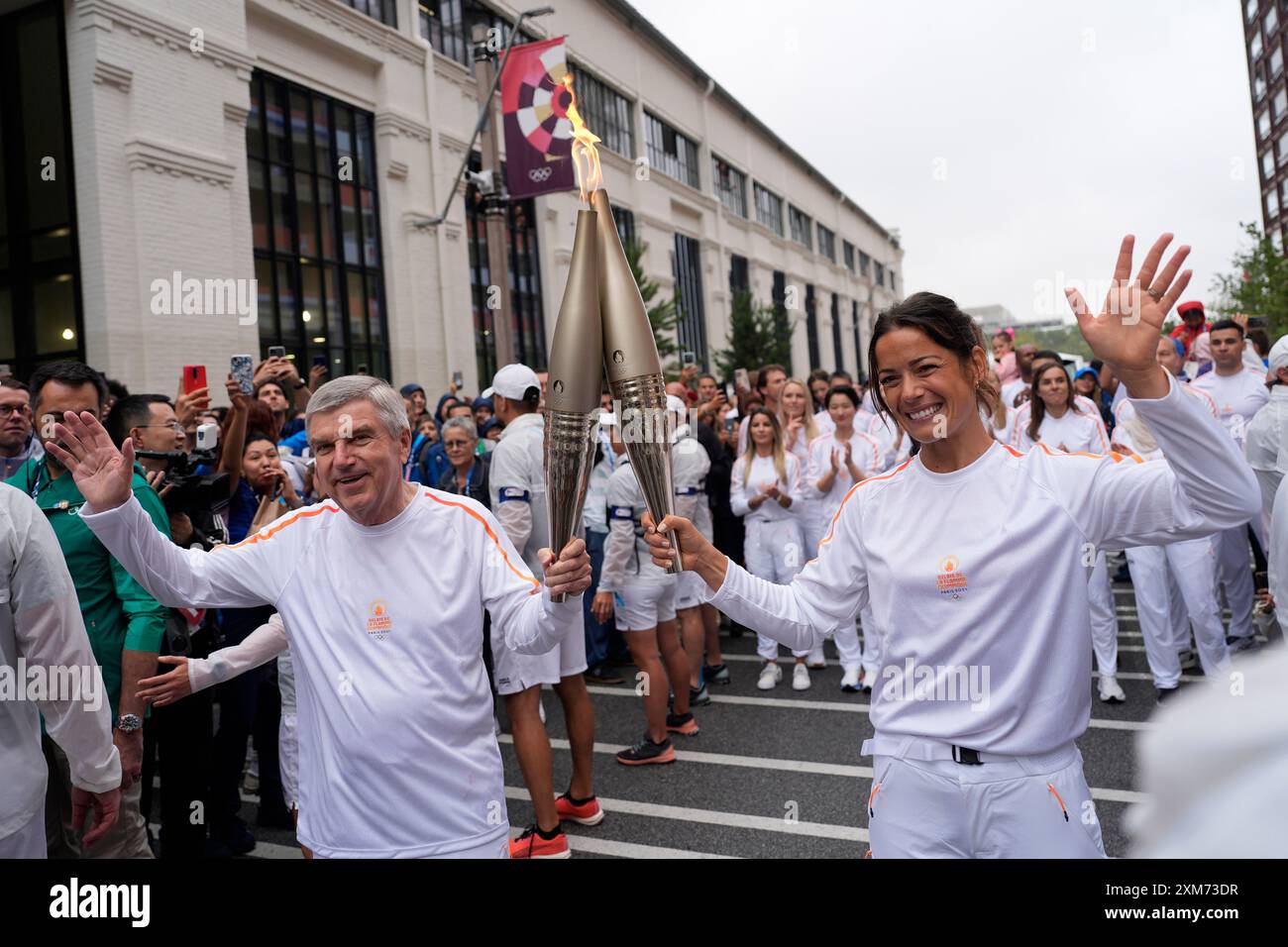 Paris, Frankreich. Juli 2024. Der Präsident des Internationalen Olympischen Komitees (IOC) Thomas Bach (Front, L) und der französische Handballspieler Cleopatre Darleux (Front, R) nehmen am 26. Juli 2024 im Olympischen Dorf in Paris Teil. Quelle: David Goldman/POOL/Xinhua/Alamy Live News Stockfoto