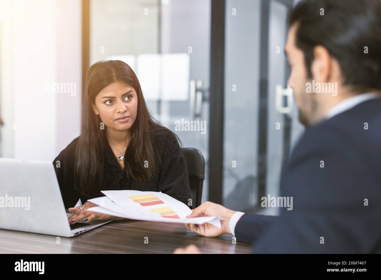 Indische Geschäftsfrauen unterhalten sich im Büro mit dem Chef, Marketingsekretärin arbeitet am Tisch mit dem Manager, der Informationen zur Entscheidung vorlegt Stockfoto