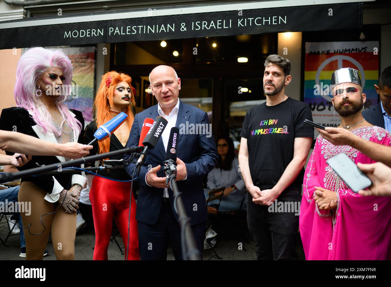 Berlin, Deutschland. Juli 2024. Kai Wegner (CDU, Zentrum), Regierender Bürgermeister von Berlin, besucht das israelisch-palästinensische Restaurant „Kanaan“ und kommentiert die Vorfälle zusammen mit dem Eigentümer des Restaurants, Oz Ben David (2. V. rechts). Die Polizei ermittelt nach einem Einbruch im Restaurant in Prenzlauer Berg. Die Besitzer hatten von einem "verabscheuungswürdigen Akt des Vandalismus" gesprochen. Quelle: Bernd von Jutrczenka/dpa/Alamy Live News Stockfoto