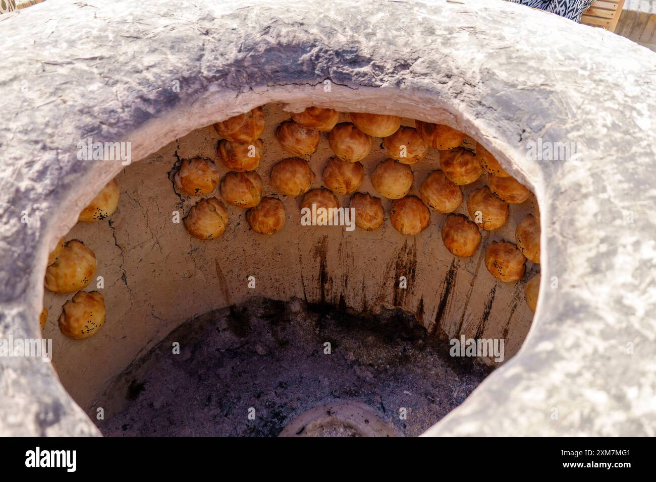 Brot wird an den Wänden eines Backofens in Chiwa, Region Chorazm, Usbekistan gebacken Stockfoto