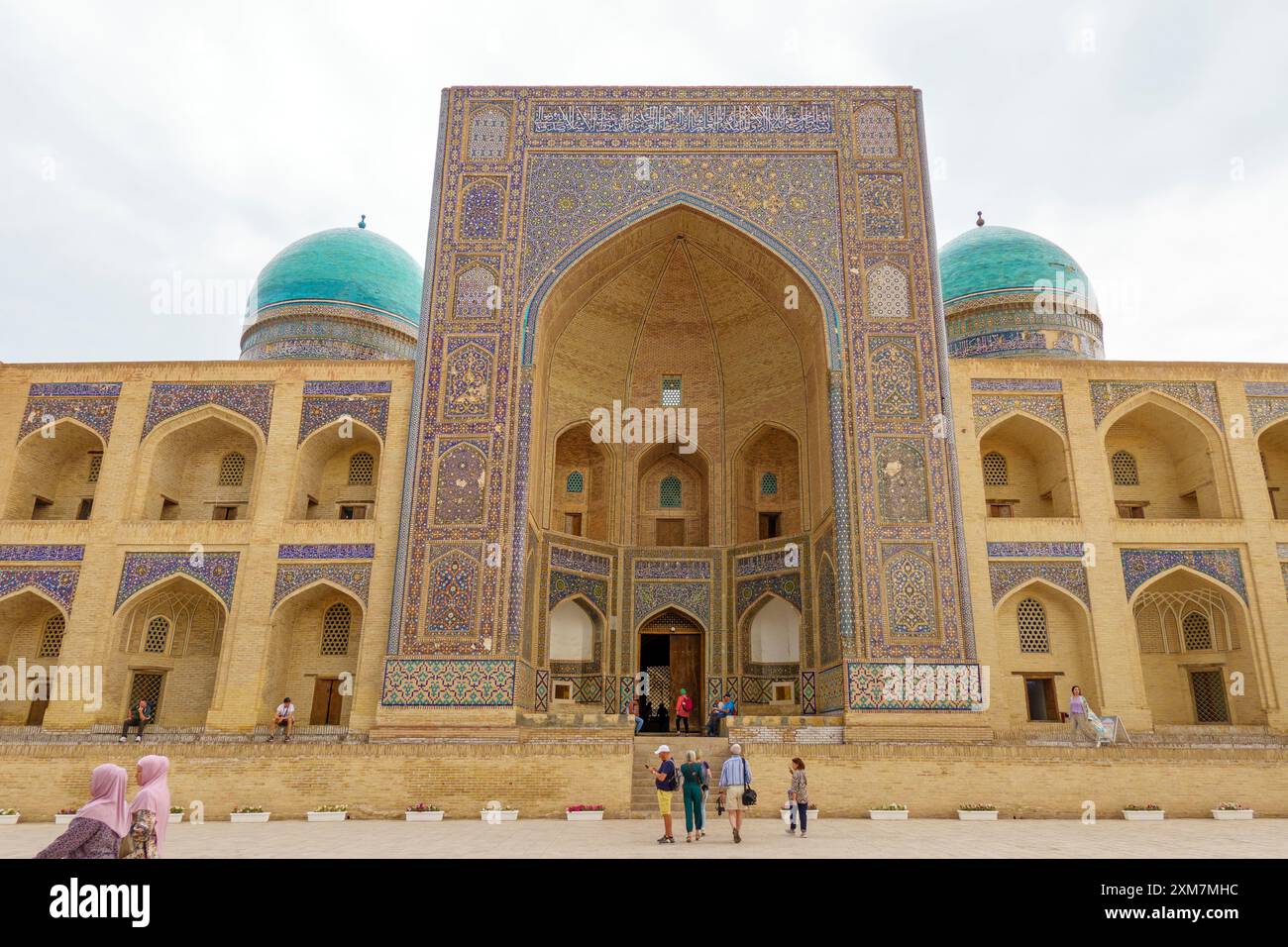Touristen besuchen die historische mir-i-Arab Madrasa mit atemberaubender islamischer Architektur und blauen Kuppeln in Buchara, Usbekistan Stockfoto