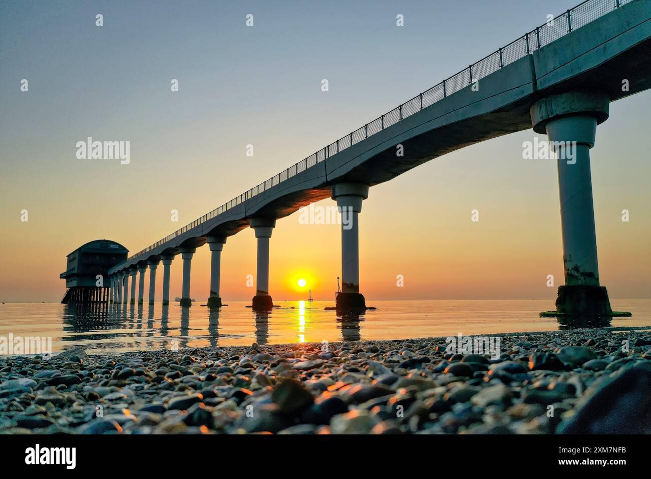 Bembridge Lifeboat Station auf der Isle of Wight mit einem üppigen Sonnenaufgang mit flachem, ruhigem Meer und lebhaften Farben Stockfoto