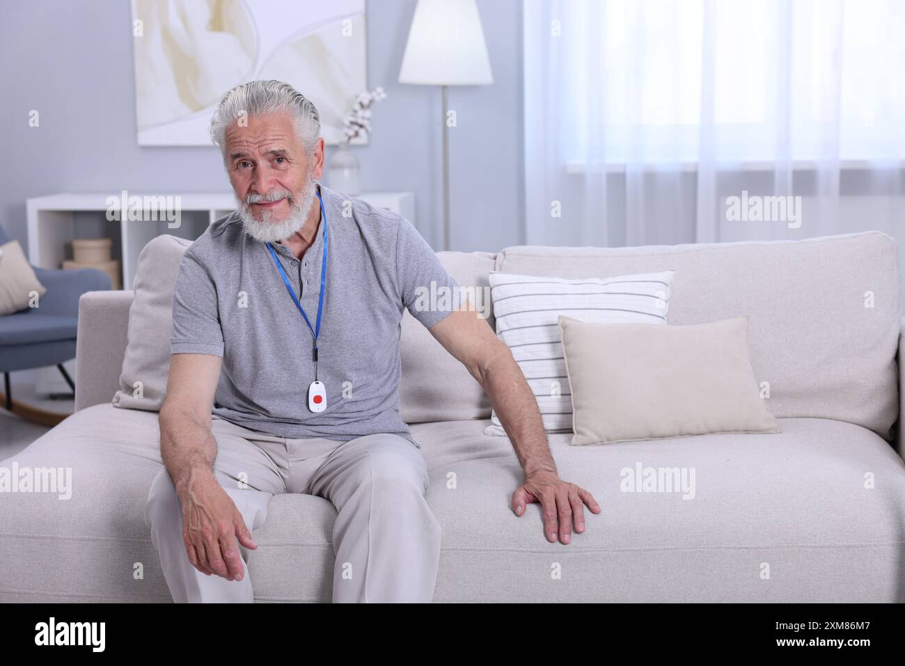 Senior Mann mit Notruftaste zu Hause Stockfoto