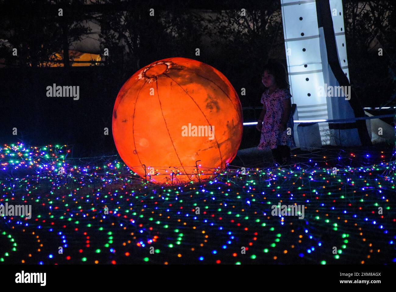 Bandung, Indonesien. Juli 2024. Ein Kind sieht sich eine Installation von Himmelskörpern an, während er am 26. Juli 2024 den Galactic Glow-Spielplatz besucht, dessen Galaxie-Thema den Weltraum darstellt. (Foto: Dimas Rachmatsyah/SIPA USA) Credit: SIPA USA/Alamy Live News Stockfoto