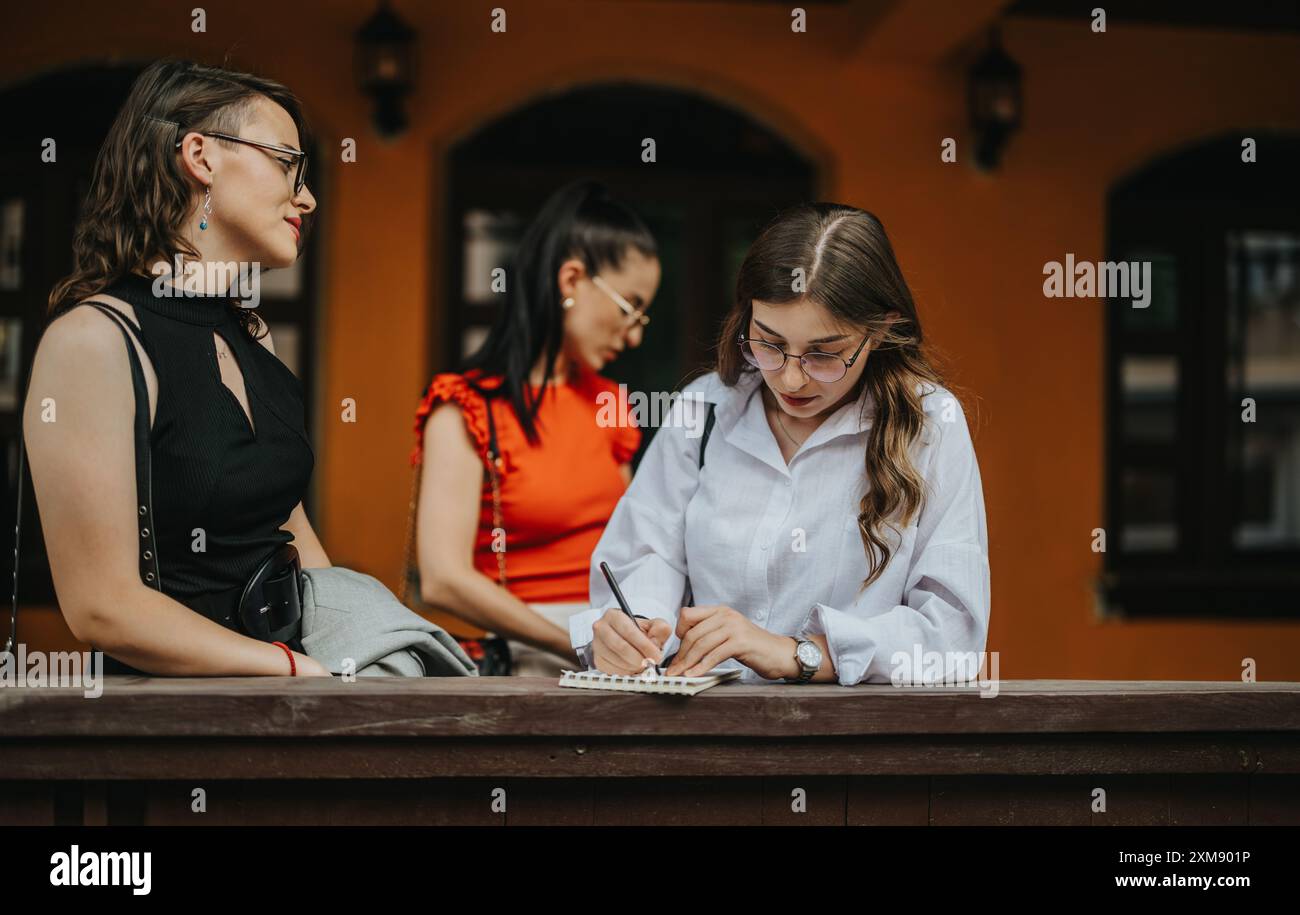 Geschäftsfrauen, die ein Treffen im Freien veranstalten und sich Notizen in einer ungezwungenen Umgebung machen Stockfoto