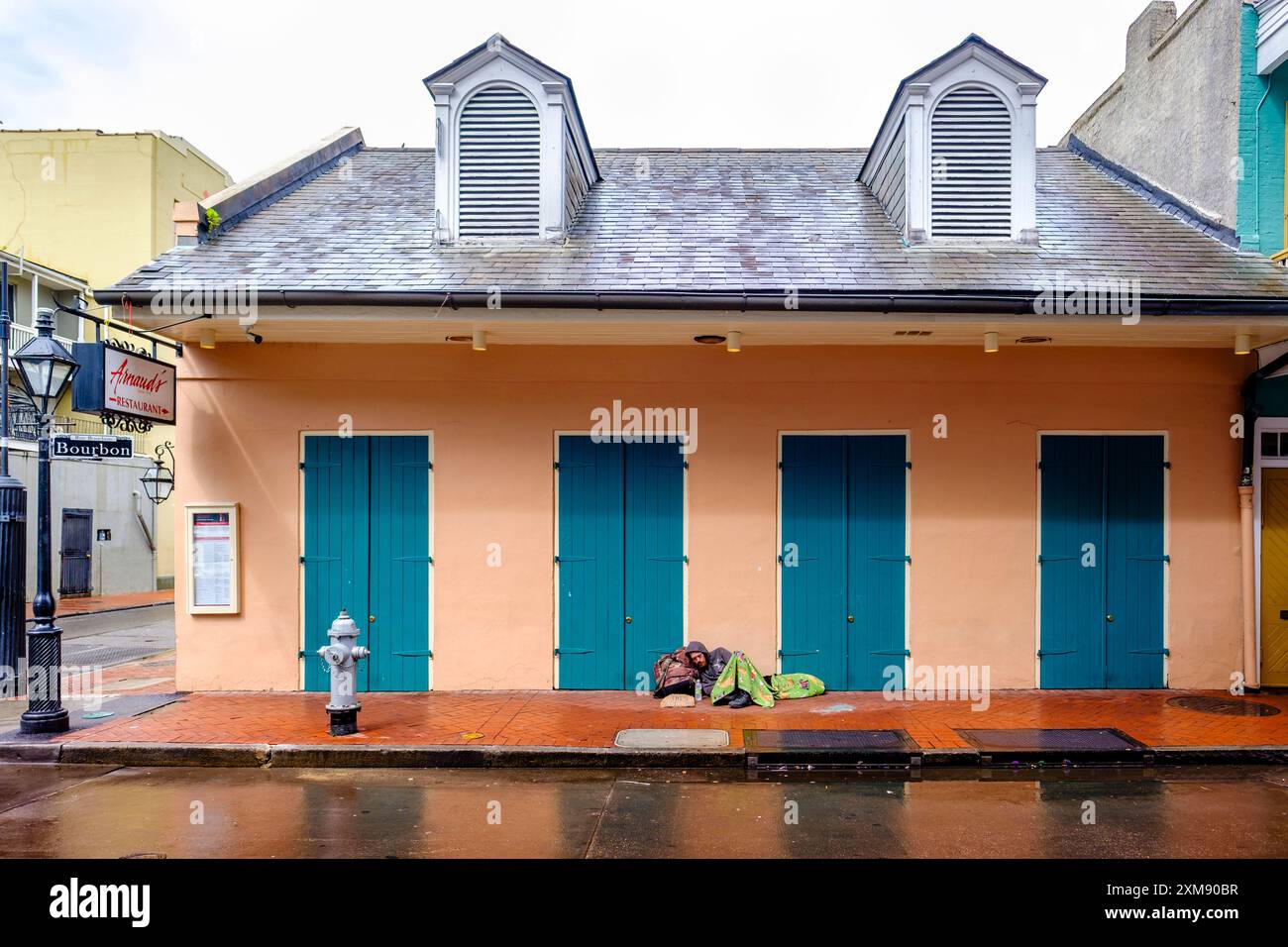 Wohnungskrise, Obdachloser schläft auf dem Bürgersteig vor Arnaud's Restaurant, Bourbon Street, New Orleans, Louisiana, USA Stockfoto