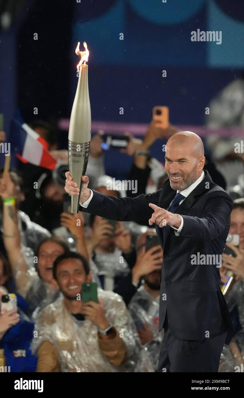 Paris, Frankreich. Juli 2024. Die französische Fußballlegende Zinedine Zidane hält die olympische Flamme während der Eröffnungszeremonie der Olympischen Spiele 2024 in Paris am Freitag, den 26. Juli 2024. Mehr als 10.000 Athleten aus 206 Ländern werden an den Olympischen Sommerspielen teilnehmen, die vom 26. Juli bis 11. August stattfinden. Foto: Richard Ellis/UPI Credit: UPI/Alamy Live News Stockfoto