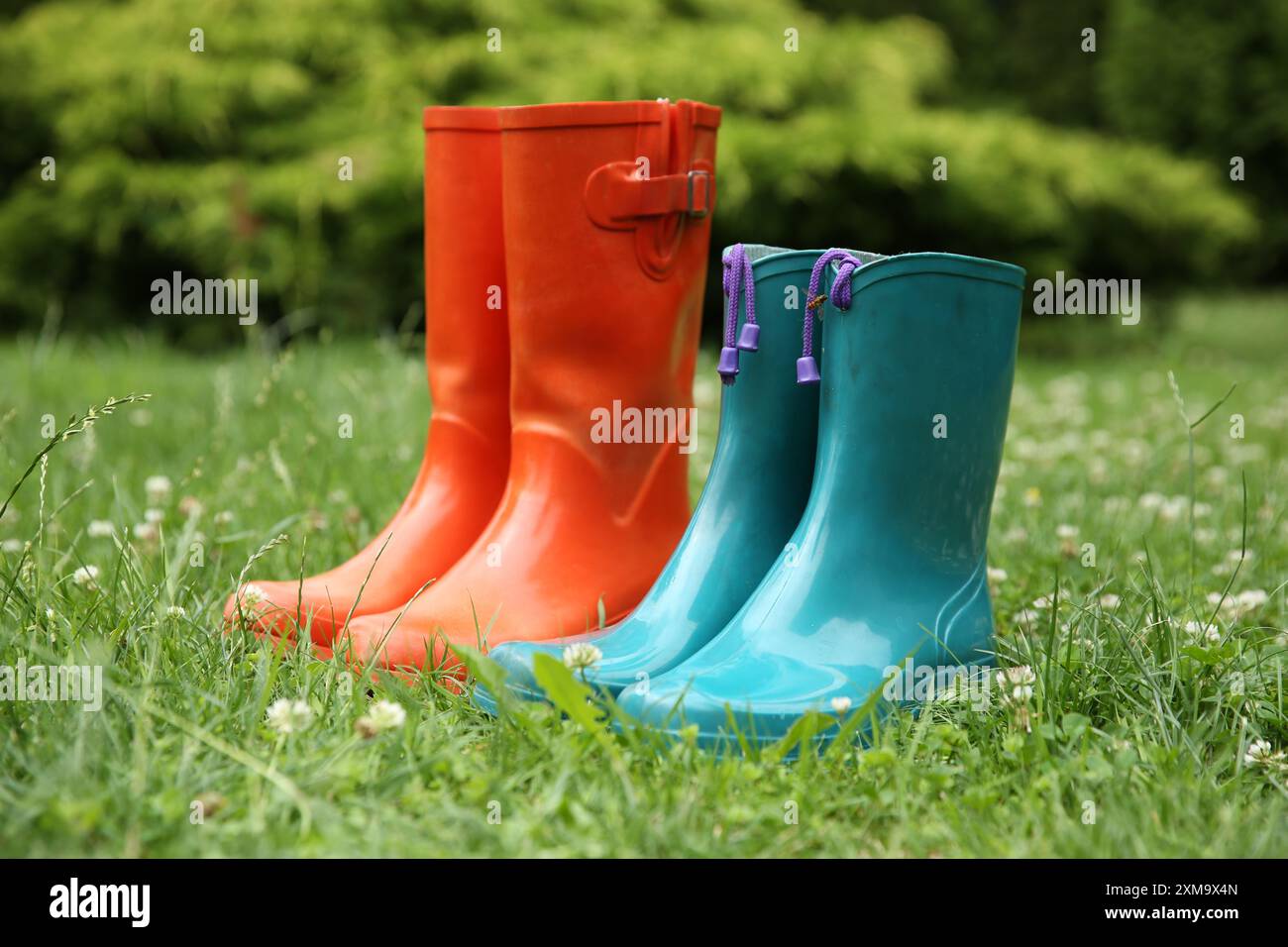 Zwei Paar Gummistiefel auf grünem Gras im Freien Stockfoto