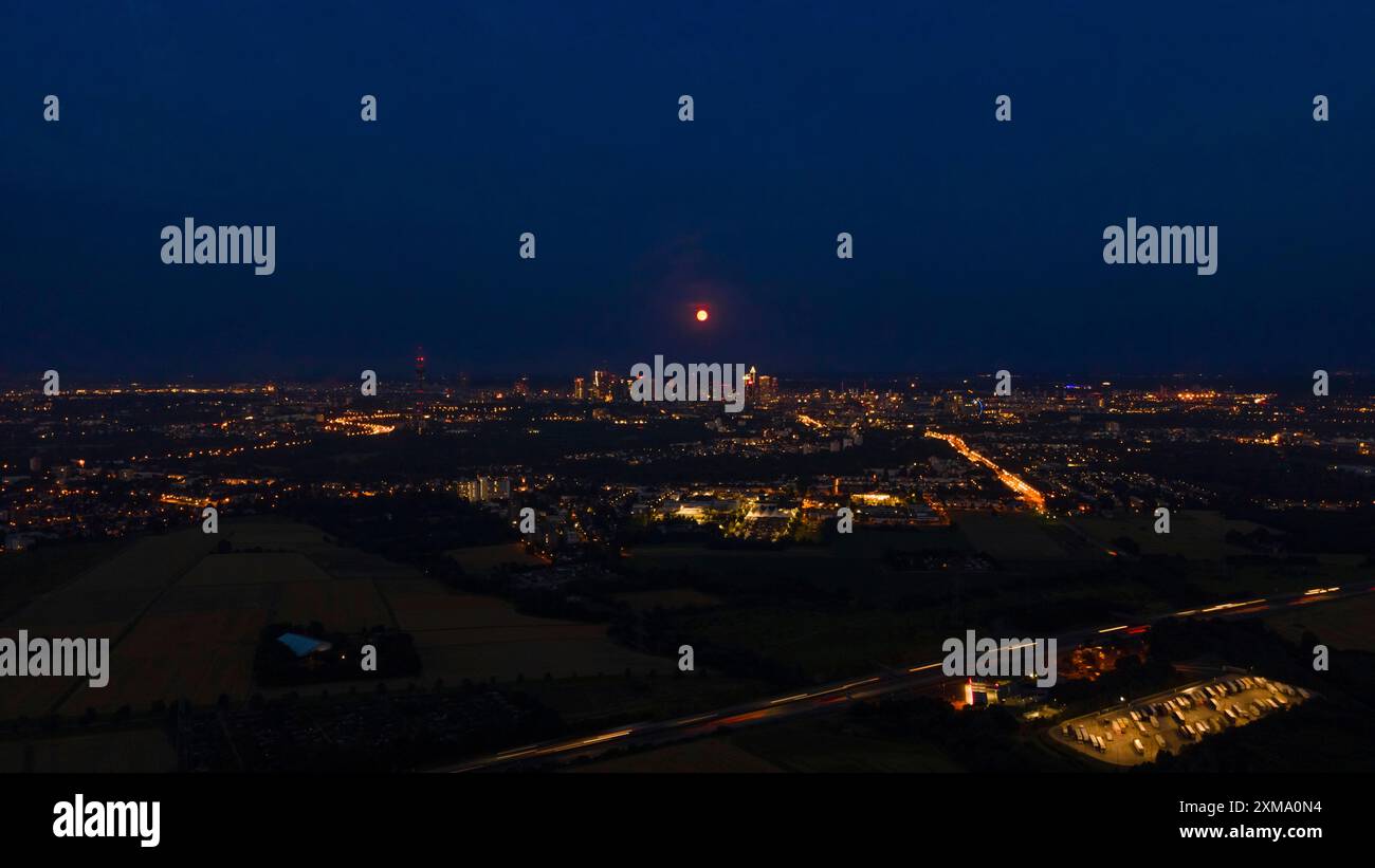 Der rote Vollmond überquert Frankfurts Bank-Skyline. Wegen seiner rötlichen Farbe beim Aufsteigen wird der Vollmond im Juli auch als der bezeichnet Stockfoto