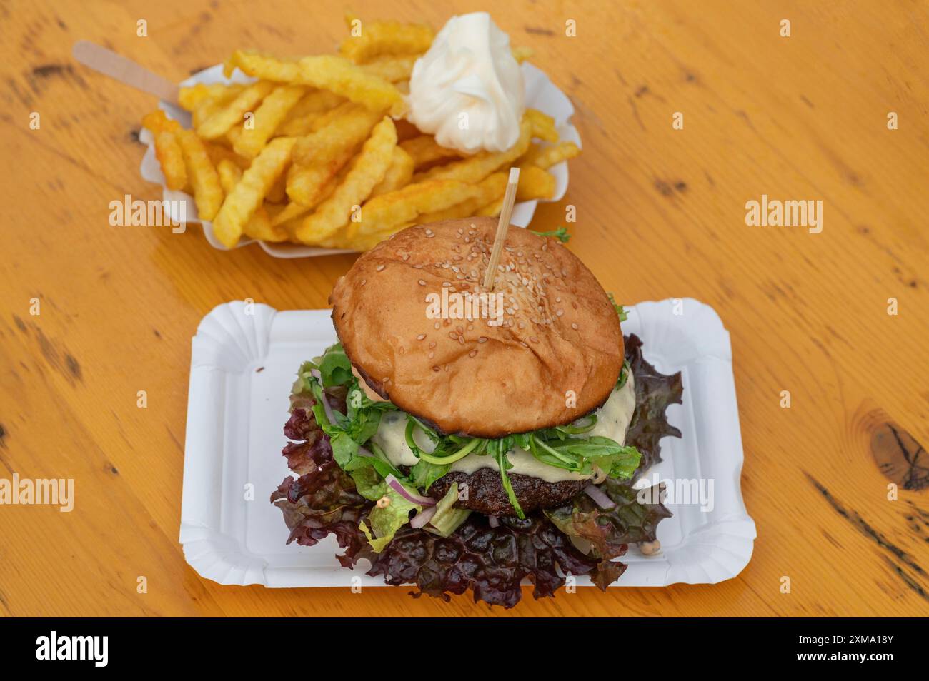 Großer Mac und Pommes frites mit Mayonnaise, auf Holztisch, Bayern, Deutschland Stockfoto