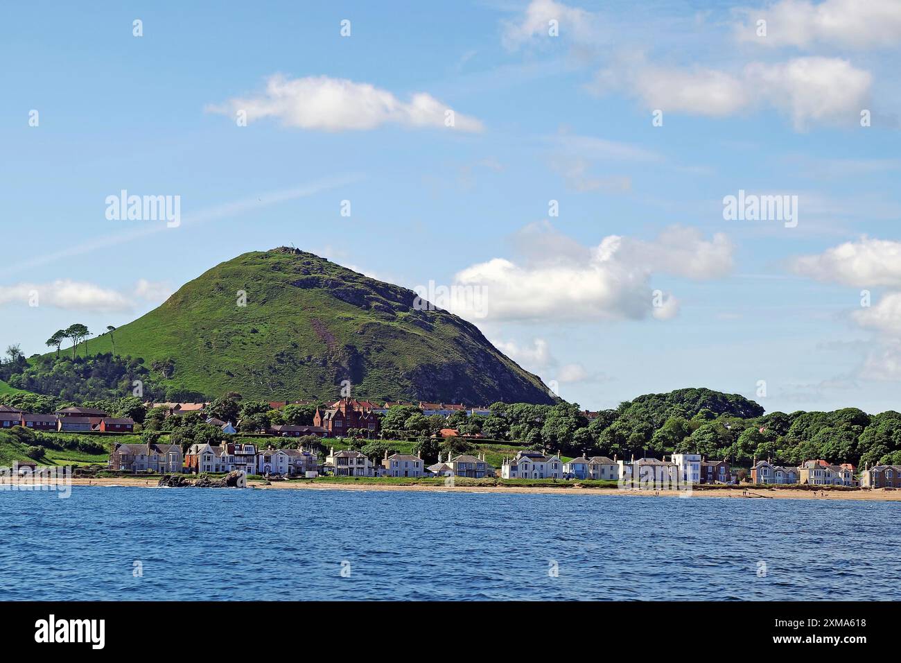 Küstenstadt mit Häusern und einem grünen Hügel im Hintergrund am Meer, North Berwick, Schottland, Vereinigtes Königreich Stockfoto