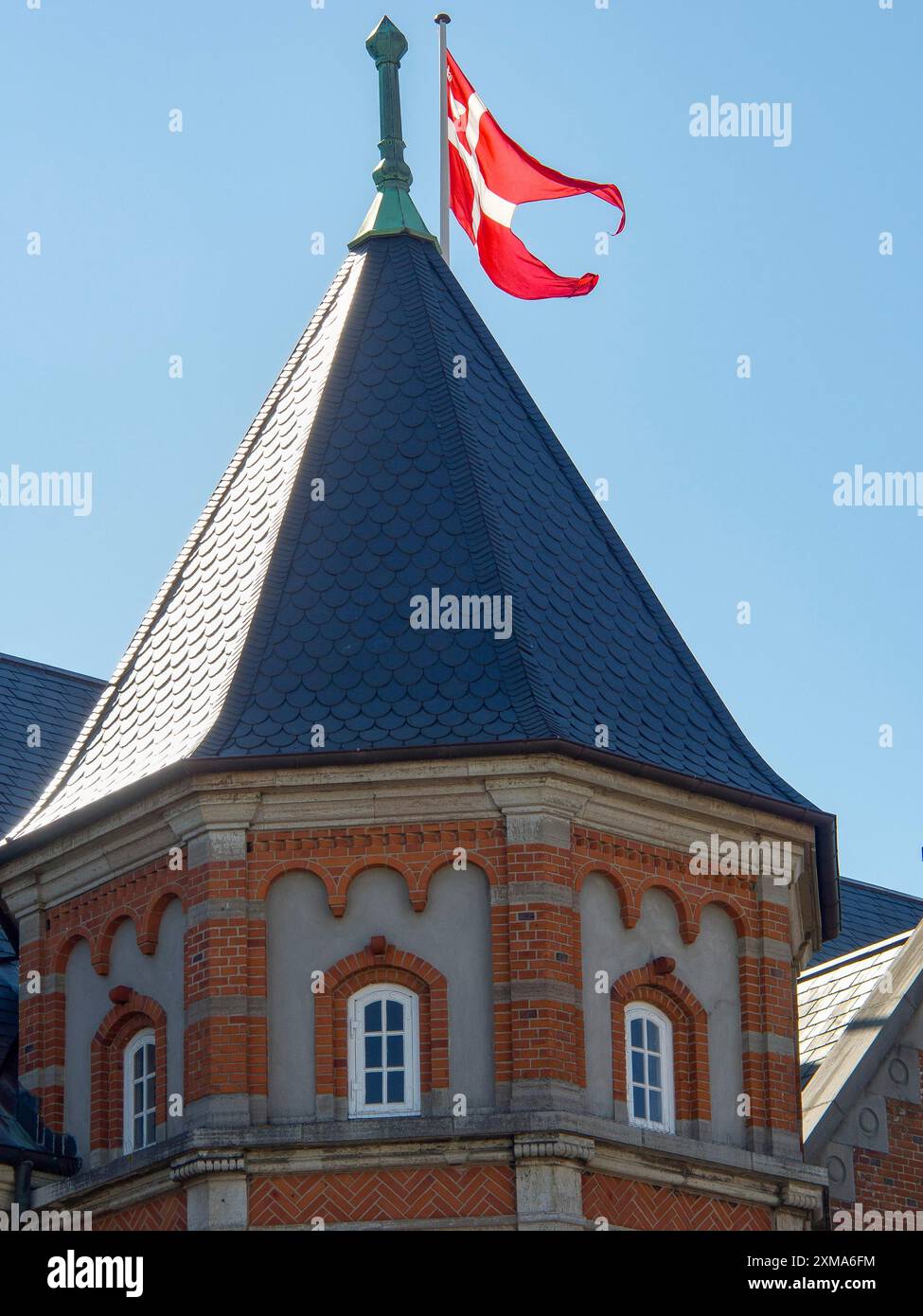 Turm mit rotem Backstein und schwenkender roter Flagge unter klarem blauen Himmel, esbjerg, dänemark Stockfoto